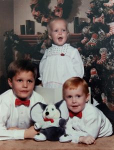 adoption in the 1990s | three siblings in front of a Christmas tree smiling 