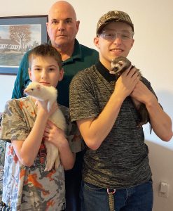 two adopted boys holding ferrets with their dad | foster care adoption