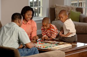 African American family playing Monopoly