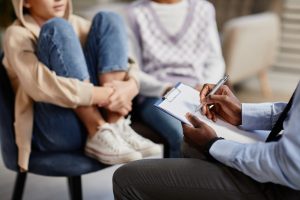 A mental health professional in a therapy session with a teenage girl and her mother.